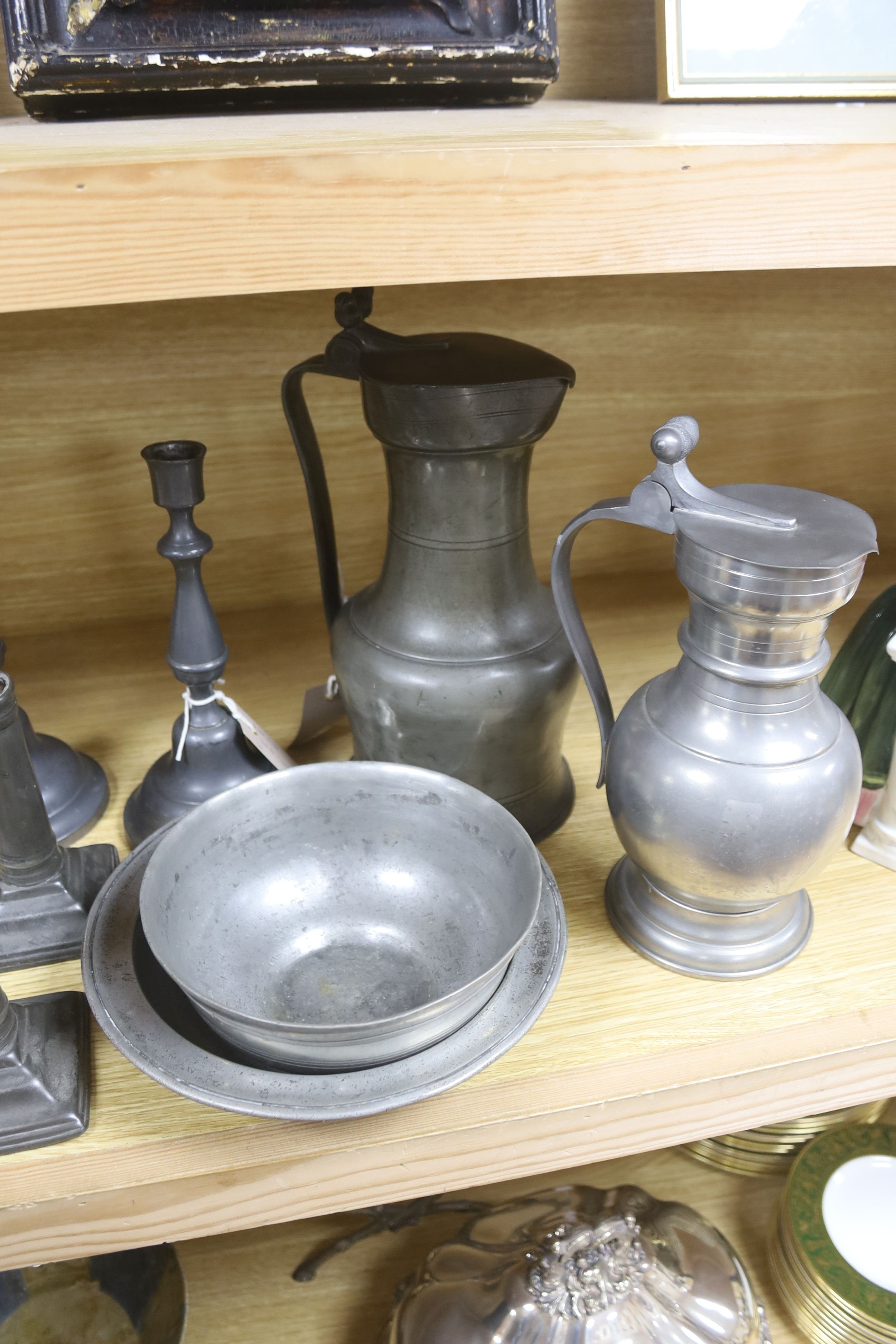 A French lidded pewter jug with double acorn thumbpiece, two pairs of pewter candlesticks and nine other items of pewter (14)